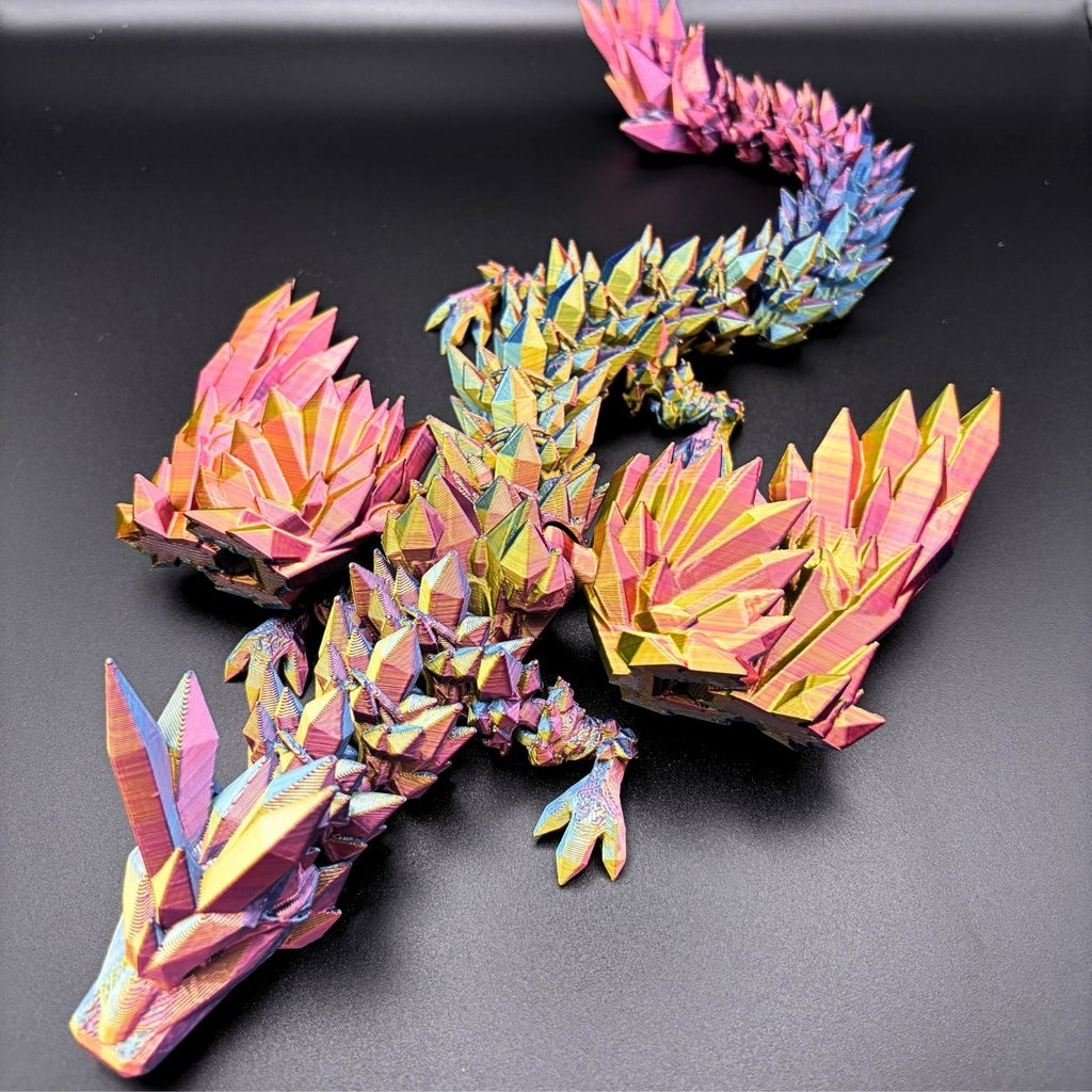 A colorful 3D papercraft dragon model with a metallic iridescent finish, displayed on a dark gray background.